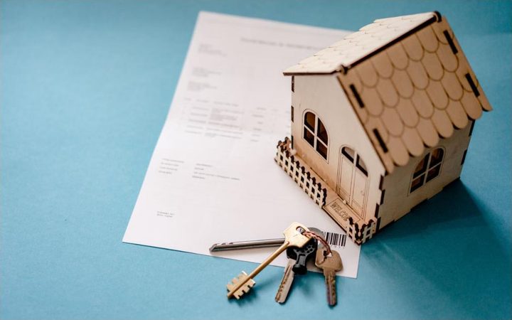 Maquete de casa e chaves sobre um contrato