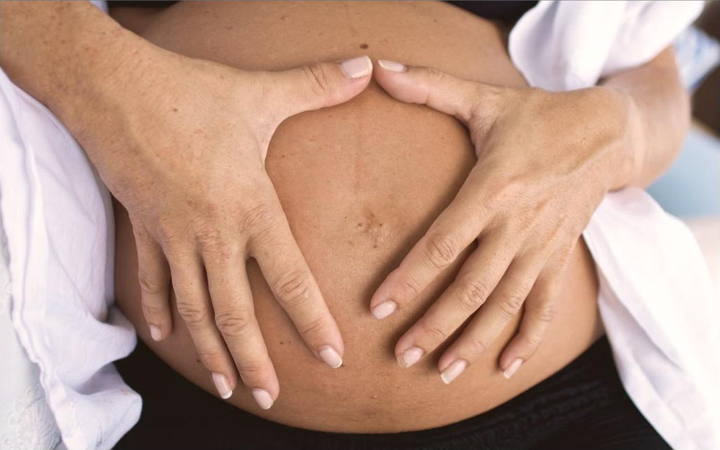 Mãos sobre a barriga de uma gestante