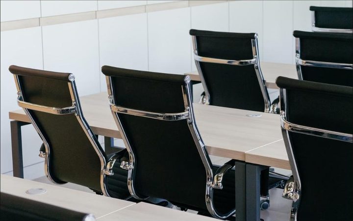 Cadeiras vazias ao redor de uma mesa de reuni&atilde;o
