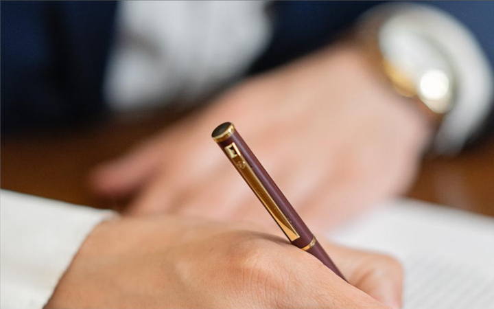 Mão assinando um documento